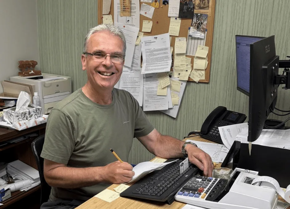 Mercer Fuels team member at an office desk with paperwork and a computer