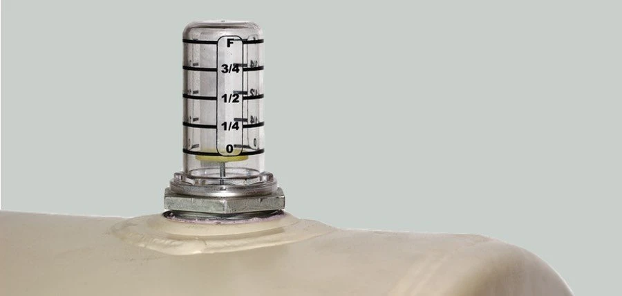 Clear upright level gauge mounted on top of a heating oil tank