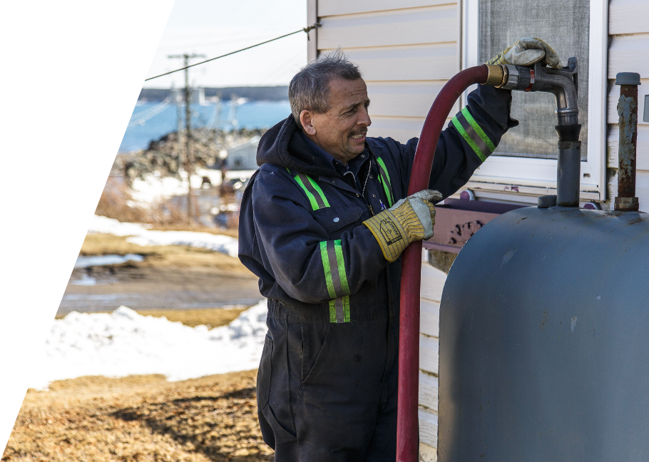 Mercer Fuels heating oil delivery technician filling outdoor home oil tank Cape Breton NS